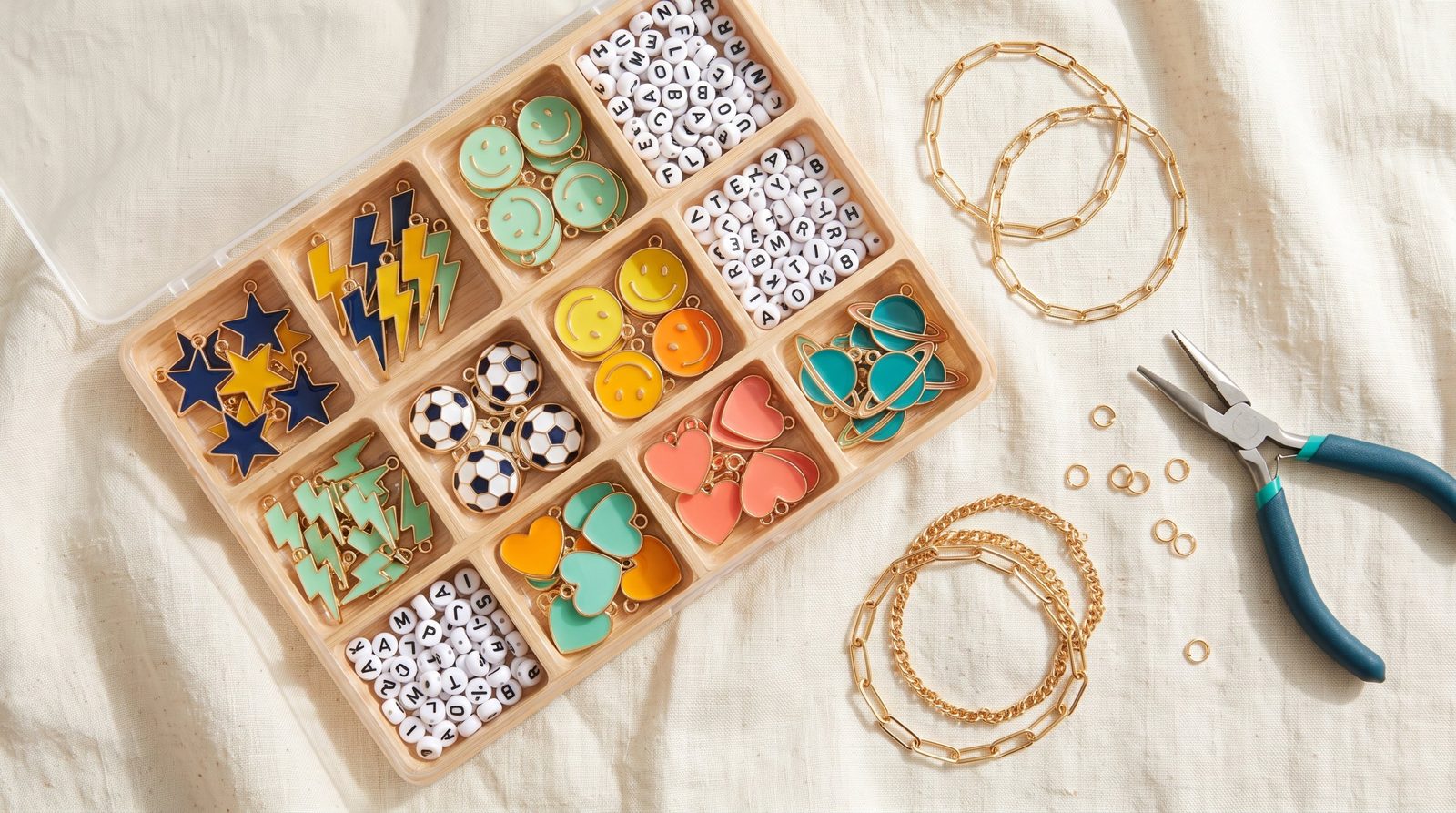 Charola con dijes de estrellas, rayos, caritas, balones, corazones y planetas
